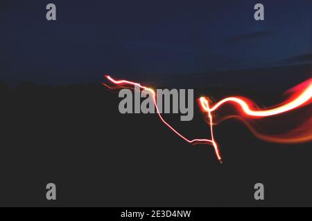 Rotlicht verwischt Bewegungsaufnahme, die einen abstrakten Hintergrund erstellt. Stockfoto