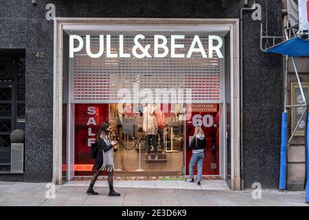 Barcelona, Spanien. Januar 2021. Kunden werden gesehen, warten an der Tür des Pull&Bear Bekleidungsgeschäft im Portal del l'Angel Einkaufsbereich für die Lieferung von Online-Käufen.aufgrund der Zunahme der Coronavirus-Infektionen, Einzelhandelsgeschäfte in Barcelona mit mehr als 400 m2 gelten weiterhin zwingende Vorschriften für die Kundenkapazität und eingeschränkte Geschäftszeiten, die während des Wochenendes vollständig geschlossen bleiben. Kredit: SOPA Images Limited/Alamy Live Nachrichten Stockfoto