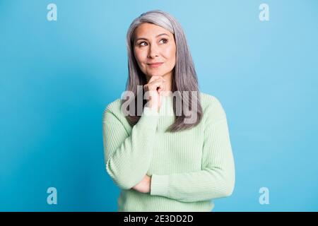 Foto von gesinnten nachdenkliche alte Dame berühren Kinn Hand aussehen Copyspace denken Gedanken isoliert über blauen Hintergrund Stockfoto