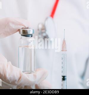 Covid 19-Impfstoff in Fläschchen und Spritze, Medizinflüssigkeit in der Hand des Arztes. Impfungen als Behandlung. Covid 19 Gesundheitswesen medizinische Immunisierung Stockfoto