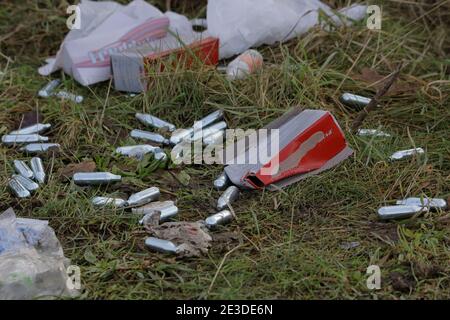 Ausrangierte Schlagsahne Ladegeräte (Schlagsahne), die von Menschen (Menschenhaufeln) mit Lachgas zurückgelassen wurden. Stockfoto