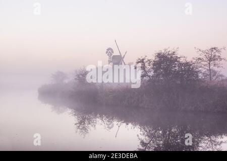 Magische Ansicht einer Windmühle in Norfolk Broads bedeckt mit Nebel Stockfoto