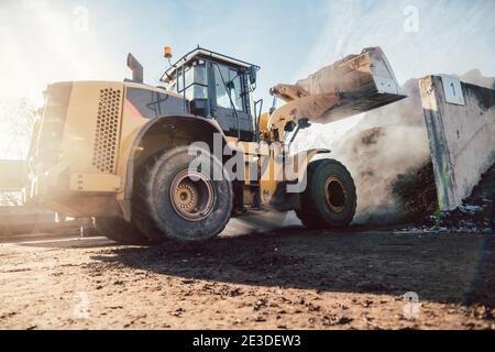 Bulldozer, der zur Kompostierung die Biomasse auf den Stapel legt Stockfoto