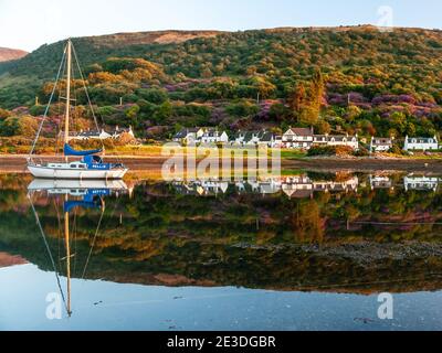 Arran, Schottland, Großbritannien - 2. Juni 2011: Die Häuser des Dorfes Lochranza spiegeln sich in den Gewässern des Firth of Clyde an der Westküste Schottlands Stockfoto