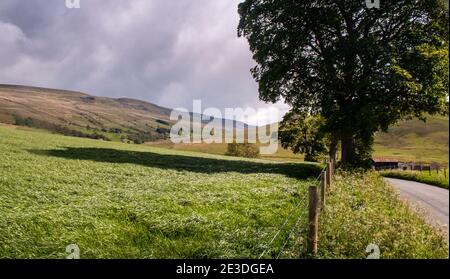 Die Sonne scheint auf dem Ackerland im Upper Eden Valley von Cumbria unter den Hügeln des Yorkshire Dales National Park in England. Stockfoto