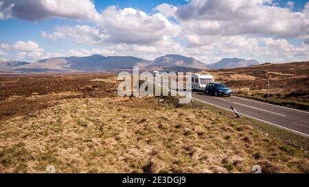 Wohnwagen fahren auf der A82 über Rannoch Moor unter den Bergen der schottischen Highlands. Stockfoto