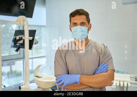 Männliche Zahntechniker trägt Maske und Handschuhe am Arbeitsplatz Stockfoto