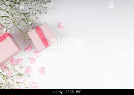 Rosa Geschenkbox auf einem rosa Hintergrund mit kleinem Weiß Blumen Stockfoto