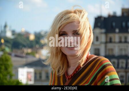 Eine Frau mit 1970-Stil Frisur und Kleidung lächelt im Freien Stockfoto