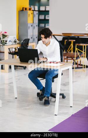 Junger mexikanischer Mann meditiert und macht Yoga im Büro in Lateinamerika Stockfoto