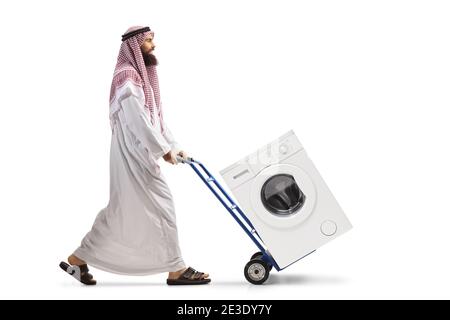 In voller Länge Profilaufnahme eines arabischen Mannes, der einen schiebt Handfahrzeug mit einer Waschmaschine isoliert auf weißem Hintergrund Stockfoto