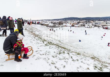 Peolpe Kinder und Erwachsene Rodeln auf dem Gelände des alten Amphitheaters im Winter auf Becsi-Domb, Sopron, Ungarn Stockfoto