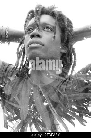 Ein schwarz-weiß junger Mann's Doppelbelichtung Porträt mit Palmblätter Stockfoto