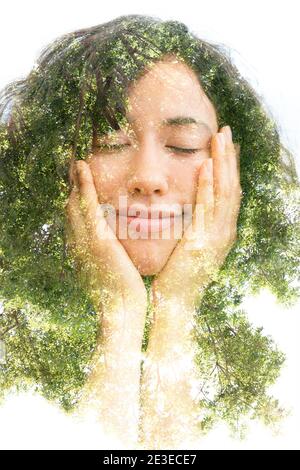 Ein Doppelbelichtungs-Porträt einer halblächelnden jungen Frau Mit geschlossenen Augen hält ihr Kinn mit den Händen und ein Baum Stockfoto