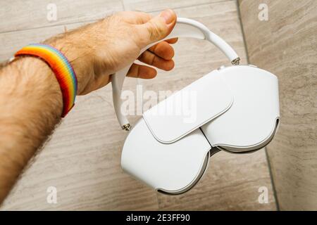 Paris, Frankreich - Jan 7, 2020: POV männliche Hand hält gegen Stein Background Wand die neuen Apple Computers AirPods Max Over-Ear Kopfhörer mit Adaptive EQ, Active Noise Cancellation, Transparency Mode h1 Chips und Siri Stockfoto