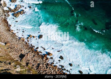 Hintergrund Textur eines felsigen Ufer und blau und türkis Wasser und Wellen des Atlantischen Ozeans am Kap Der guten Hoffnung in Südafrika Stockfoto