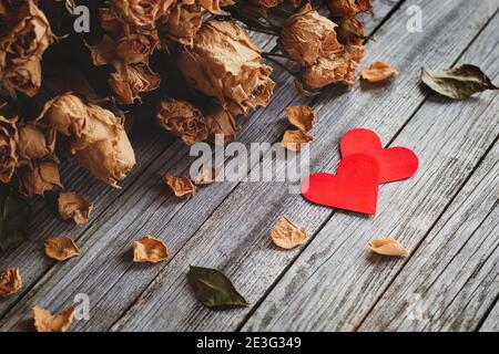 Zwei rote Herzen mit Strauß trockener Rosen auf Holz Hintergrund Stockfoto