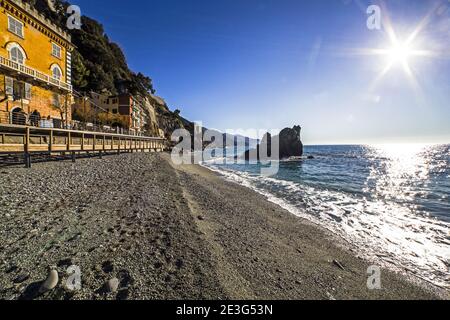 Meeresblick auf Monterosso Strand gegen Wellen, Sonnenlicht und Felsen, ein italienisches Dorf am Mittelmeer im Cinque Terre Nationalpark, La Spe Stockfoto