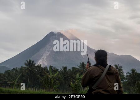 Sleman, YOGYAKARTA, INDONESIEN. Januar 2021. Am Dienstag, den 19. Januar 2021, überwachen die Bewohner den Berg Merapi in Sleman, Yogyakarta, Indonesien. Das Geological Seismic Technology Research and Development Center (BPPTKG) berichtete, dass es bei 02.27 WIB zu heißen Lawinenwolken kam. Heiße Wolken wurden auf einem Seismogramm mit einer Amplitude von 60 mm für 209 Sekunden aufgezeichnet. Entfernung von 1.8 km südwestlich des Flusses Krasak-Boyong. Die sichere Entfernung liegt im Umkreis von 5 Kilometern vom Gipfel. Quelle: Slamet Riyadi/ZUMA Wire/Alamy Live News Stockfoto