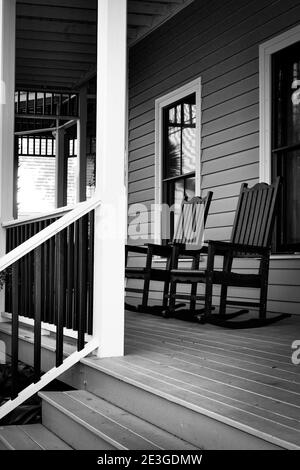 Nahaufnahme der südlichen Gastfreundschaft mit Schaukelstühlen auf der Veranda eines zweistöckigen Inn in Fernandina Beach auf Amelia Island, FL Stockfoto