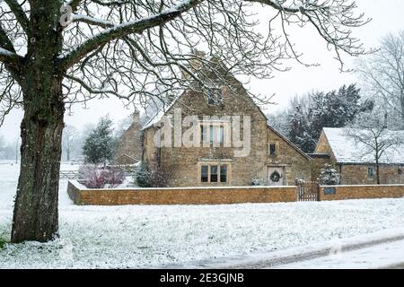 Cotswold Steinhütte im Dezember Schnee. Wyck Rissington, Cotswolds, Gloucestershire, England Stockfoto