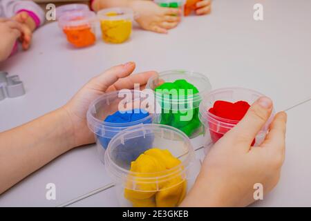 Junge glückliche Kinder spielen mit buntem Teig, Stockfoto