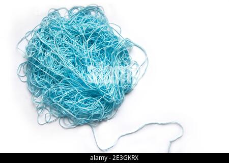 Das Konzept des Brainstormings. Ein Gewirr aus Minze, blauen Baumwollfäden, Nadelarbeitsgarn auf weißem Hintergrund. Stockfoto