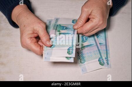 Ältere Frau zählt tausend Rubel Rechnungen. Hände und Geld der alten Frau. Alter, Altersvorsorge und Investitionskonzept. Stockfoto