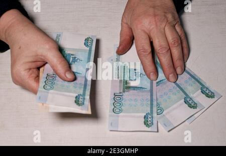 Ältere Frau zählt tausend Rubel Rechnungen. Hände und Geld der alten Frau. Alter, Altersvorsorge und Investitionskonzept. Stockfoto