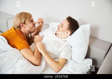Glücklich Gay paar liegen im Bett und Spaß haben Stockfoto