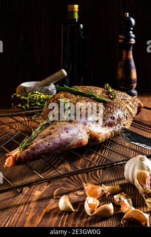 Mariniertes Lammbein mit Gewürzen und Kräutern, Olivenöl und Knoblauch zum Backen bereit Stockfoto