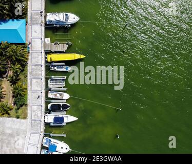 Pier mit Paddelbooten, Schlauchbooten und Booten. Luftaufnahme von oben von der Drohne. Cancuns grüne Laguna Nichupte Stockfoto