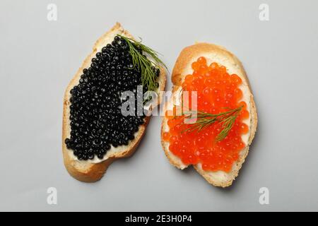 Sandwiches mit rotem und schwarzem Kaviar auf grauem Hintergrund, Draufsicht Stockfoto
