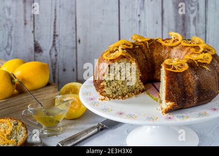 Zitronen- und Mohnkuchen mit kandierten Fruchtscheiben Und Zitronenglasur Stockfoto