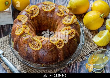 Zitronen- und Mohnkuchen mit kandierten Fruchtscheiben Und Zitronenglasur Stockfoto