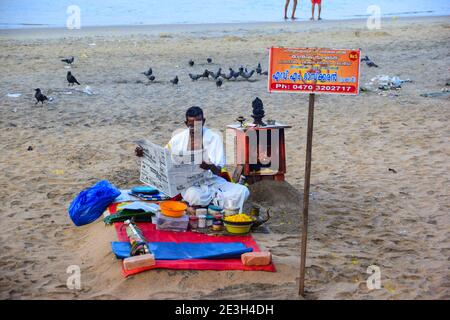 Hindu Priester Zeitung lesen, vor dem Waschen weg Sünden der Pilger, Varkala Beach, Varkala, Kerala, Indien Stockfoto