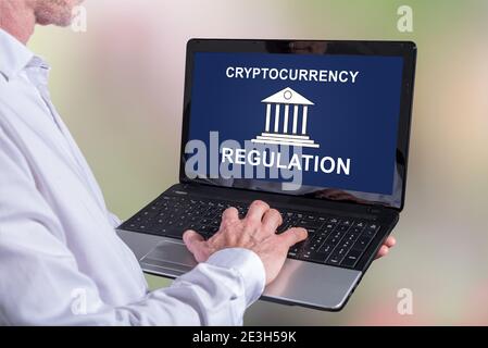 Mann, der einen Laptop mit Kryptowährungsregelungskonzept auf dem verwendet Angezeigt Stockfoto