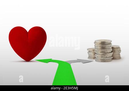 Zwei-Wege-Pfeile mit Herz und Münzen - Konzept Liebe statt Geld wählen Stockfoto