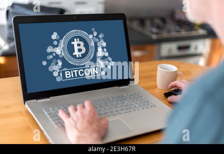 Mann mit einem Laptop mit Bitcoin-Konzept auf dem Bildschirm Stockfoto