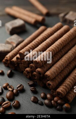 Tablett mit Schokoladenwaffelrollen, Kaffeebohnen und Schokolade, Nahaufnahme Stockfoto