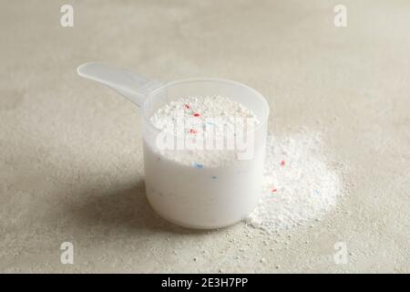 Schaufel mit Waschpulver auf hellbeige strukturiertem Hintergrund Stockfoto
