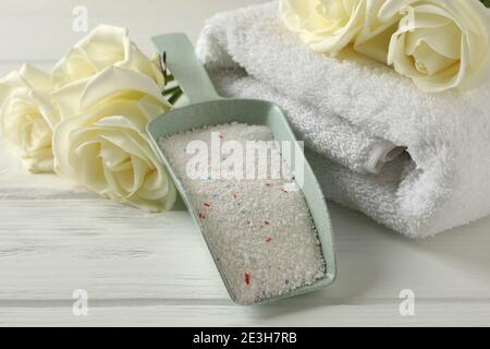 Schaufel mit Puder, Rosen und Handtüchern auf weißem Holzhintergrund Stockfoto