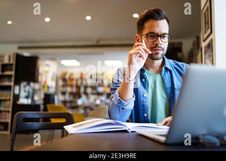 Der Schüler bereitet die Prüfung und den Lernunterricht in der Schulbibliothek vor Stockfoto