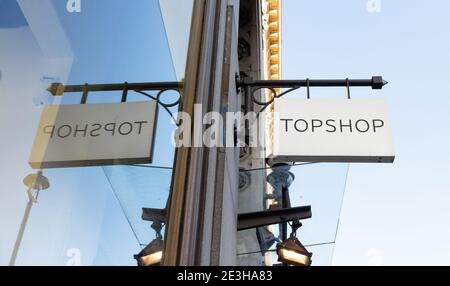 London / UK - 5. November 2020 - Topshop-Schild spiegelt sich in einem Schaufenster auf der Oxford Street. Topshop ist ein britischer multinationaler Modehändler Stockfoto