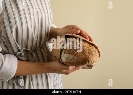 Frau in Schürze halten frisch gebackenes Brot Stockfoto