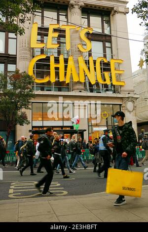 Eine Menge Demonstranten auf der Baker Street marschieren in Richtung Scotland Yard, demonstrieren gegen Coronavirus-Einschränkungen, während das Zeichen eines Geschäfts im Hintergrund buchstabiert: ÒLetÕs ChangeÓ. Stockfoto