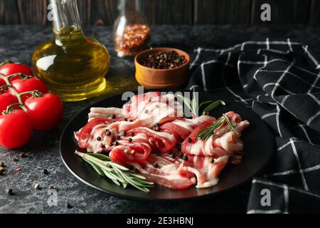 Konzept der leckeren Snack mit Platte Speck auf schwarz Rauchige Hintergrundfarbe Stockfoto