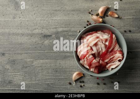 Schüssel mit Speck und Gewürzen auf grauem Hintergrund Stockfoto