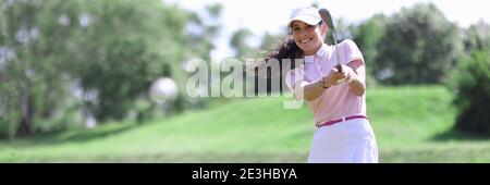 Lächelnde Erwachsene kaukasische Frau im Golfclub schlagen auf Ball Porträt. Stockfoto