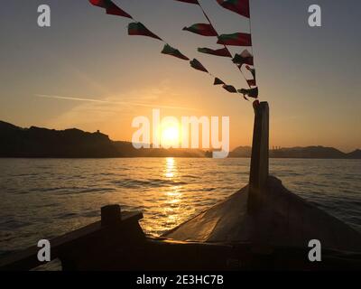 Bootstour bei Sonnenuntergang auf einer traditionellen Dhow, Muscat, Sultanat von Oman Stockfoto